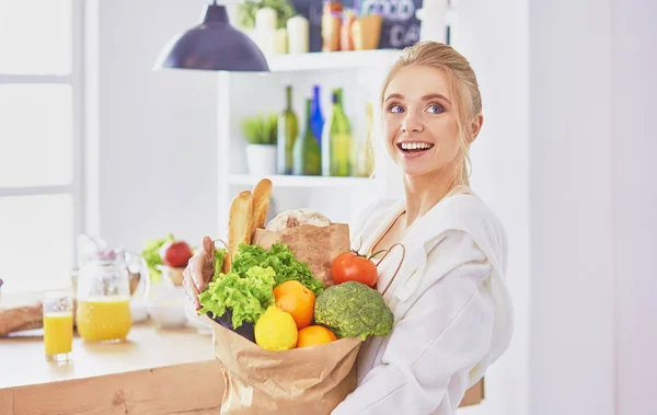 Mladá žena drží nákupní tašky s potravinami s zeleninou legitimace — Stock fotografie
