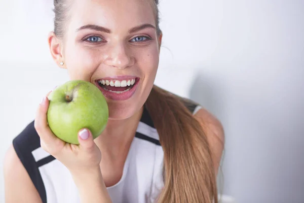 Unga vackra leende flicka med ett grönt äpple i händer — Stockfoto