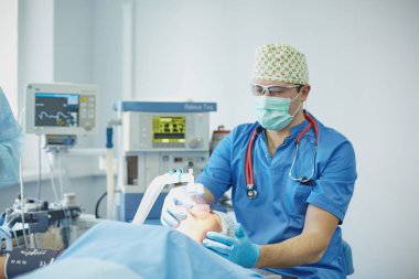 Birkaç doktor hasta operasyon masası üzerinde onların çalışma sırasında çevreleyen. Takım cerrahlar ameliyathane içinde işte