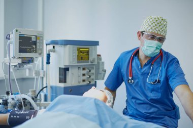 T sırasında ameliyat masasında hasta çevreleyen birkaç doktor