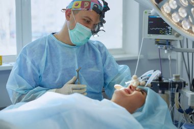 Birkaç doktor hasta operasyon masası üzerinde onların çalışma sırasında çevreleyen. Takım cerrahlar ameliyathane içinde işte