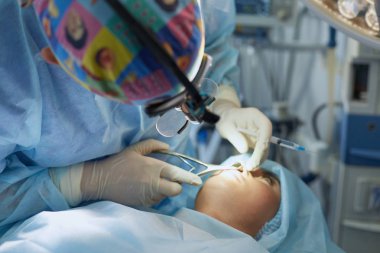 Birkaç doktor hasta operasyon masası üzerinde onların çalışma sırasında çevreleyen. Takım cerrahlar ameliyathane içinde işte