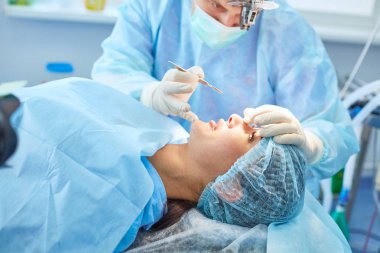 Birkaç doktor hasta operasyon masası üzerinde onların çalışma sırasında çevreleyen. Takım cerrahlar ameliyathane içinde işte