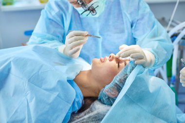 Birkaç doktor hasta operasyon masası üzerinde onların çalışma sırasında çevreleyen. Takım cerrahlar ameliyathane içinde işte