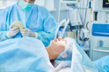Birkaç doktor hasta operasyon masası üzerinde onların çalışma sırasında çevreleyen. Takım cerrahlar ameliyathane içinde işte