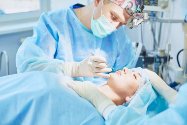 Birkaç doktor hasta operasyon masası üzerinde onların çalışma sırasında çevreleyen. Takım cerrahlar ameliyathane içinde işte