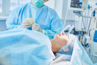 Birkaç doktor hasta operasyon masası üzerinde onların çalışma sırasında çevreleyen. Takım cerrahlar ameliyathane içinde işte