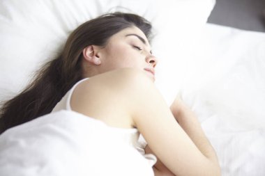 güzel genç kadın yatakta sabah tadını çıkarma. Güzel Model yüz kamera seksi görünüyor