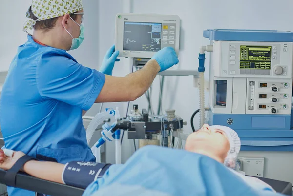 Plusieurs médecins entourant le patient sur la table d'opération pendant t — Photo