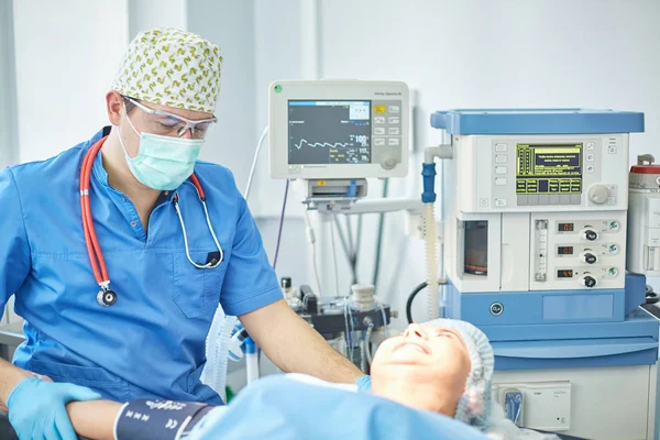 Plusieurs médecins entourant le patient sur la table d'opération pendant leur travail. Chirurgiens d'équipe au travail en salle d'opération — Photo