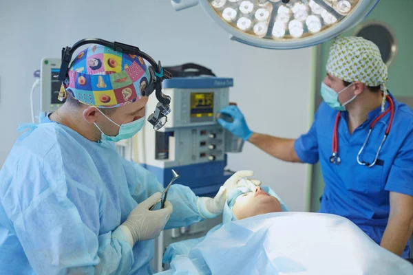 몇몇 의사는 그들의 일 동안 작업 테이블에 환자를 둘러싼. 팀 외과 수술 실에서 직장에서 — 스톡 사진