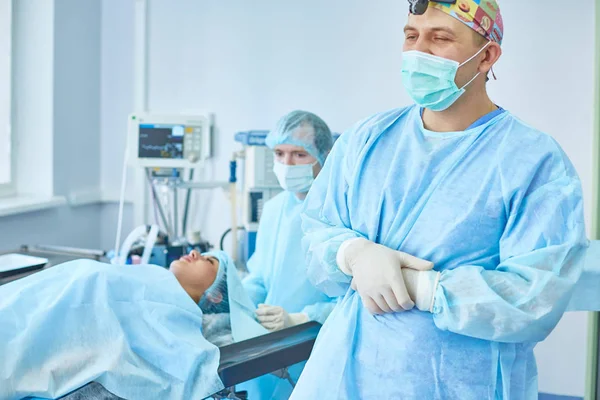 Flera läkare som omger patienten på operationsbordet under t — Stockfoto