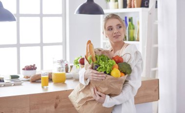 bakkal alışveriş çantası ile sebze standi tutan genç kadın