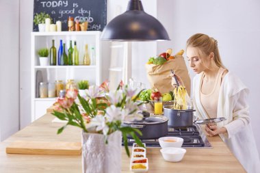 Genç kadın mutfakta yemek pişiriyor. Sağlıklı Yemek