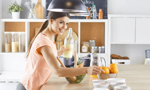 Happy young cook girl preparing food from greens — Stock Photo, Image