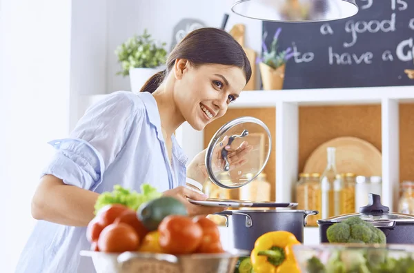 Imagen de una joven chica bonita de pie en la cocina y es coo — Foto de Stock