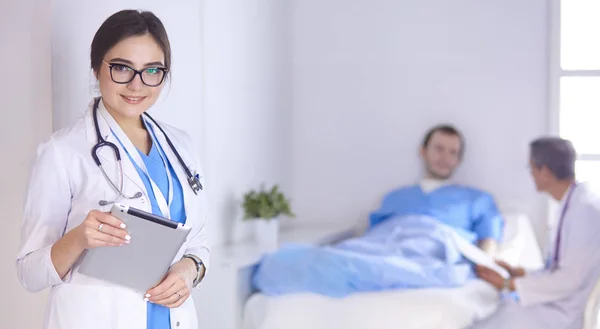 Doctor checking heart beat of patient in bed with stethoscope — Stock Photo, Image