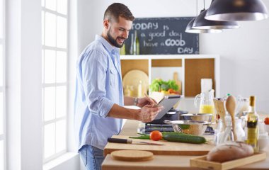 Gülümseyen ve kendinden emin şef büyük mutfakta duruyor.