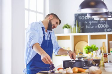 Yemek pişirme, meslek ve insan konsepti. Lokanta mutfağında akıllı telefonlu erkek aşçı.