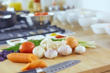 Ahşap tahtalı kompozisyon ve masada yemek pişirmek için malzemeler