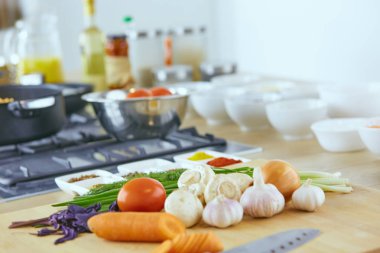 Ahşap tahtalı kompozisyon ve masada yemek pişirmek için malzemeler