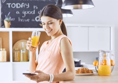 Cep telefonu görünümlü ve cam tutan gülümseyen güzel kadın 