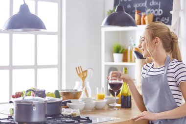 güzel bir kadın mutfakta şarap kırmızı içme