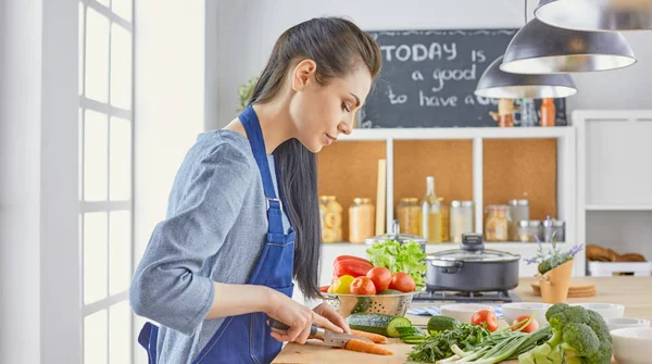 Una giovane donna prepara il cibo in cucina. Cibo sano - insalata vegetale. Dieta. Il concetto di dieta. Uno stile di vita sano. Cucinare a casa. Cuoco — Foto Stock