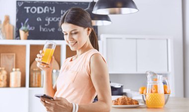 Cep telefonu görünümlü ve cam tutan gülümseyen güzel kadın 