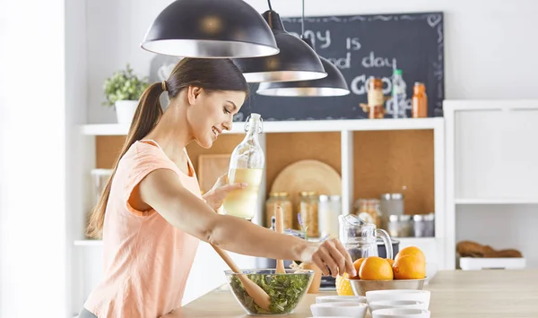 Happy young cook girl preparing food from greens — Stock Photo, Image