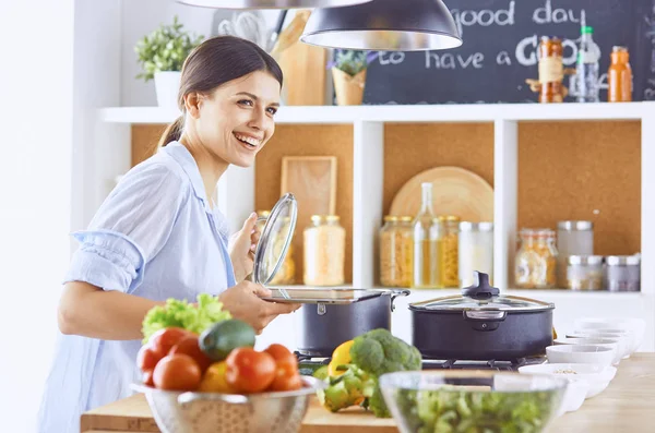 Uma jovem prepara comida na cozinha. Alimentos saudáveis - vege — Fotografia de Stock