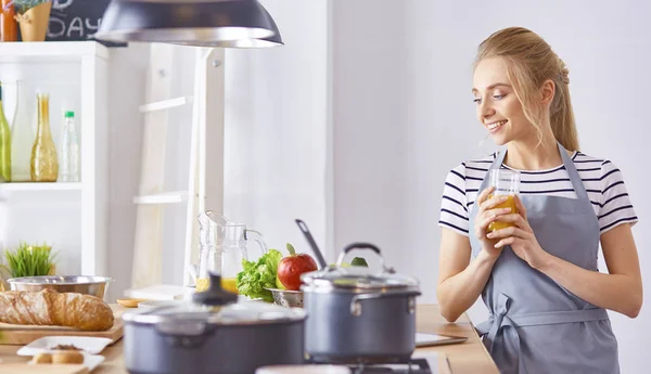 The girl at the table in the kitchen with a glass of orange jui — Stock Photo, Image