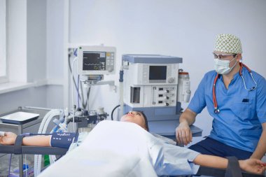 T sırasında ameliyat masasında hasta çevreleyen birkaç doktor