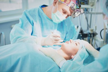 T sırasında ameliyat masasında hasta çevreleyen birkaç doktor