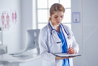 Genç kadın doktor Pano gülümseyerek ile kurulu ile ayakta