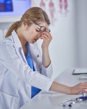 Genç kadın doktor bilgisayar ile çalıştıktan sonra yorgun