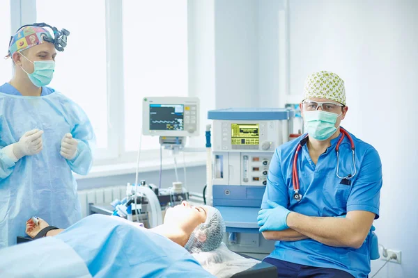 Кілька лікарів, що оточують пацієнта на операційному столі під час т — стокове фото
