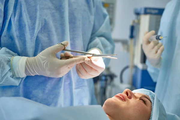 Varios médicos que rodean al paciente en la mesa de operaciones durante t — Foto de Stock