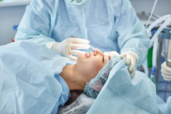 Plusieurs médecins entourant le patient sur la table d'opération pendant t — Photo