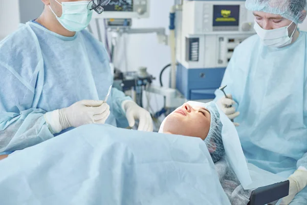 Vários médicos em torno do paciente na mesa de operação durante t — Fotografia de Stock