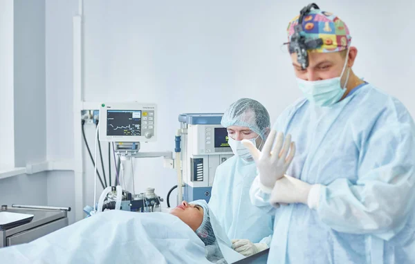 Plusieurs médecins entourant le patient sur la table d'opération pendant t — Photo