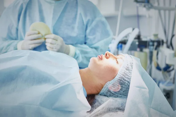 Useat potilaita ympäröivät lääkärit leikkauspöydällä — kuvapankkivalokuva