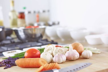 Ahşap tahtalı kompozisyon ve masada yemek pişirmek için malzemeler