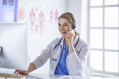 Ofiste kulaklık mutlu gülümseyen genç doktor Portresi