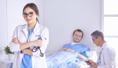 Doktor stetoskop ile yatakta hasta kalp ritmini kontrol