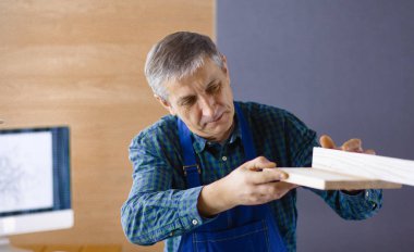 Meslek, doğrama, doğrama ve insanlar kavramı - marangoz ahşap tahta düzgünlüğünü Atölyesi'nde test