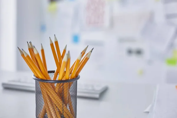 Grafiet potloden in een glazen kopje op de tafel van office. Concept. — Stockfoto