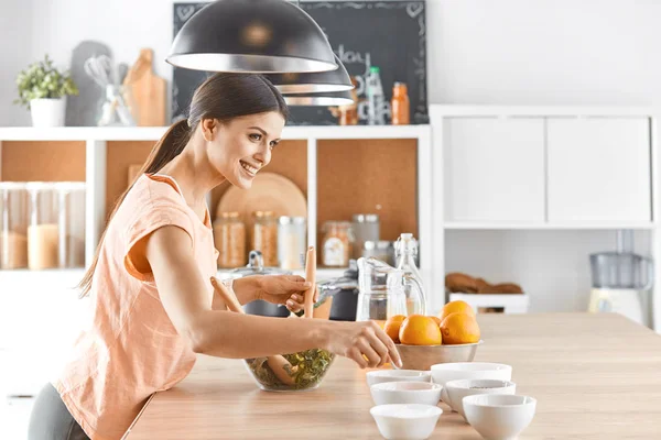 Happy young cook girl preparing food from greens — Stock Photo, Image