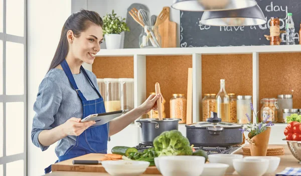 Happy woman looking recipe tablet kitchen reading cooking — Stock Photo, Image