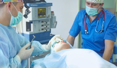 T sırasında ameliyat masasında hasta çevreleyen birkaç doktor